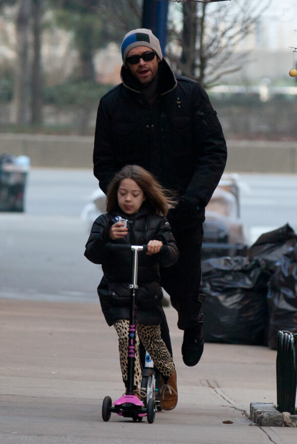 Derrière sa fille Ava, Hugh Jackman en patinette le 10 janvier 2012 à New York
