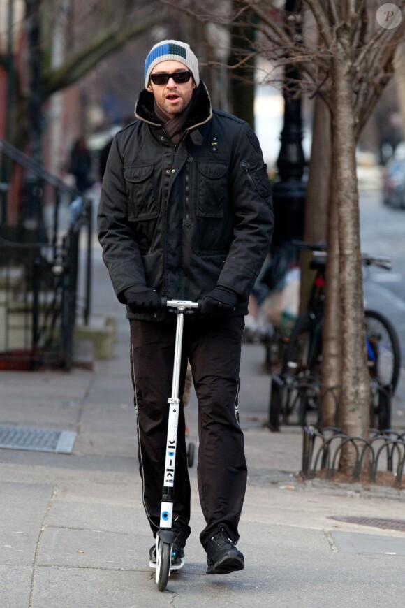 Hugh Jackman en patinette, en route pour l'école de sa fille Ava, le 10 janvier 2012 à New York