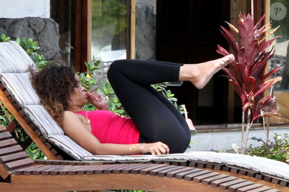 Rihanna, plongée dans ses pensées lorsqu'elle fume une cigarette roulée des plus suspicieuses durant ses vacances à Hawaï le 15 janvier 2012