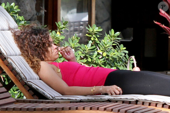 Rihanna, plongée dans ses pensées lorsqu'elle fume une cigarette roulée des plus suspicieuses durant ses vacances à Hawaï le 15 janvier 2012