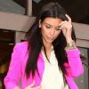 Kim Kardashian ose la couleur avec un blazer rose fuchsia et un jean pêche.