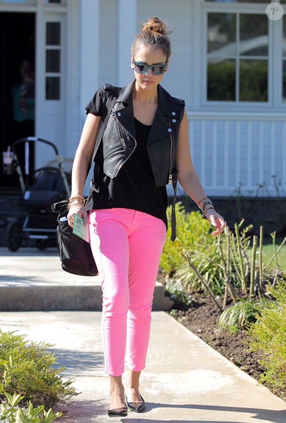 Jessica Alba ose le jean rose bonbon pour le printemps, porté avec un perfecto sans manches et des chaussures plates.