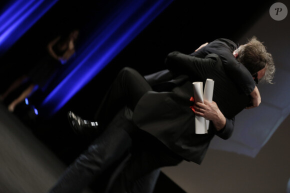 Gustave Kervern saute dans les bras du président du jury Tim Roth après avoir reçu le prix spécial du jury pour Le Grand Soir lors de la remise des prix Un Certain Regard à Cannes le 26 mai 2012