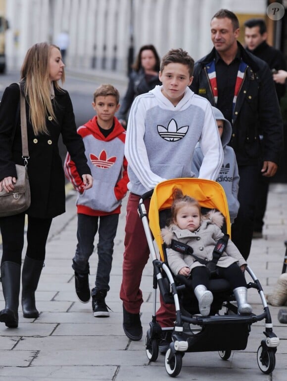 Les enfants Beckham, Brooklyn, Romeo et Cruz prennent soin de leur soeur Harper dans les rues de Londres le 23 novembre au matin. Photo exclusive