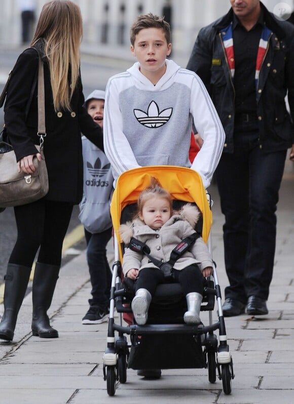 Les enfants Beckham, Brooklyn, Romeo et Cruz prennent soin de leur soeur Harper dans les rues de Londres le 23 novembre au matin lors d'une balade en famille. Photo exclusive