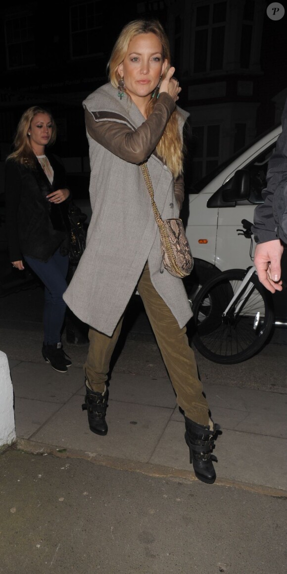 Kate Hudson quitte un concert au Shepherd's Bush Empire à Londres, habillée d'un manteau Helmut Lang avec une combinaison kaki en dessous et un sac Stella McCartney en bandoulière et des bottines Burberry. Le 19 février 2013.