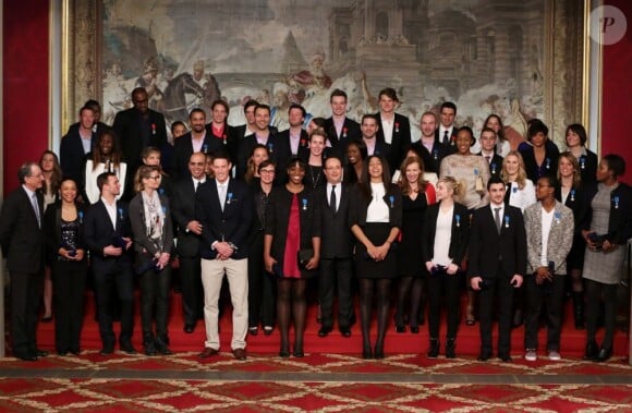François Hollande et Valérie Trierweiler entourés par les athlètes lors de la cérémonie de remise de la Légion d'honneur aux sportifs médaillés à Londres lors des Jeux olympiques, au palais de l'Elysée le 1er mars 2013 à Paris