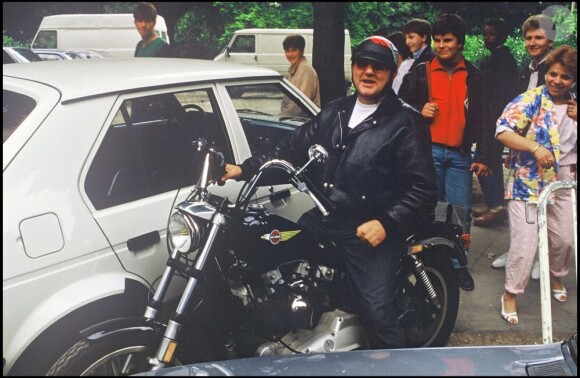 Coluche sur une moto à Paris le 30 juin 1985