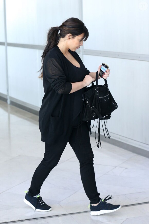Après avoir passé le week-end avec Kanye West à Paris, Kim Kardashian, enceinte, rentre à Los Angeles le 2 avril 2013. La future maman opte enfin pour des vêtements plus larges.