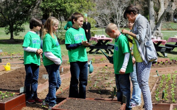 La First Lady Michelle Obama plante des légumes dans le potager de la Maison Blanche. L'épouse de Barack Obama était comme toujours entourée d'élèves. Washington le 4 avril 2013.