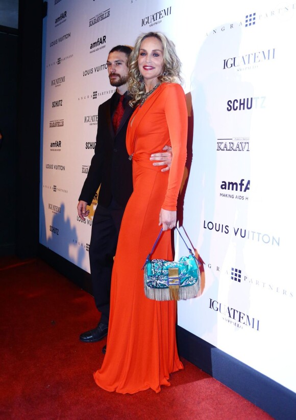 Sharon Stone et le mannequin Martin Mica au Gala de l'amfAR à São Paulo au Brésil le 5 avril 2013.