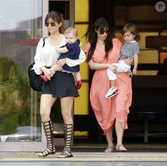 Kim et Kourtney Kardashian quittent l'église California Community Church à Agoura Hills avec Mason et Penelope (4 ans et 8 mois) dans les bras. Le 7 avril 2013.