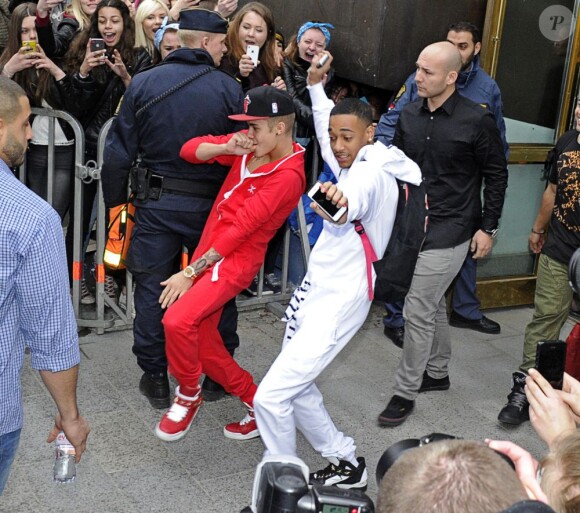 Le chanteur Justin Bieber sort de son hôtel en dansant avec un ami pour se rendre à son concert à Stockholm, le 24 avril 2013.