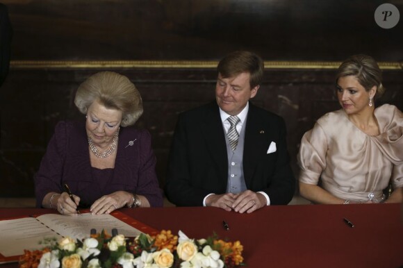 Beatrix des Pays-Bas en train d'abdiquer, sous le regard de son fils et sa belle-fille... La reine Beatrix des Pays-Bas signait le 30 avril 2013 à 10h10, en présence de membres du gouvernement dans le Mozeszaal du palais royal à Amsterdam, l'acte officiel d'abdication signifiant la fin de ses 33 ans de règne et l'intronisation de son fils le prince Willem-Alexander et son épouse Maxima.