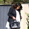 Kim Kardashian, enceinte et détendue à Los Angeles, porte avec son blazer noir et sa robe large blanche, un sac Hermès et des sandales Valentino. Le 28 mai 2013.