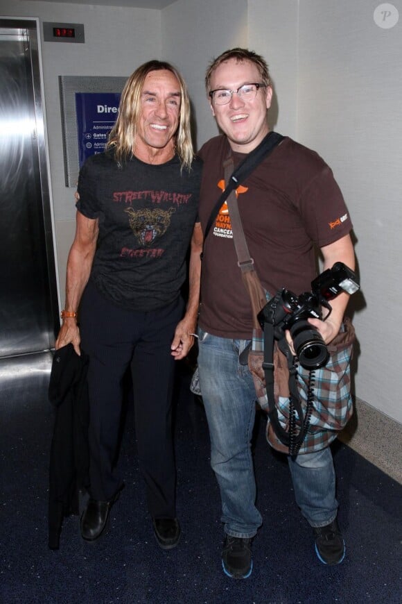 Iggy Pop avec sa compagne Nina Alu, pose avec un fan à l'aéroport de Los Angeles le 9 juin 2013.