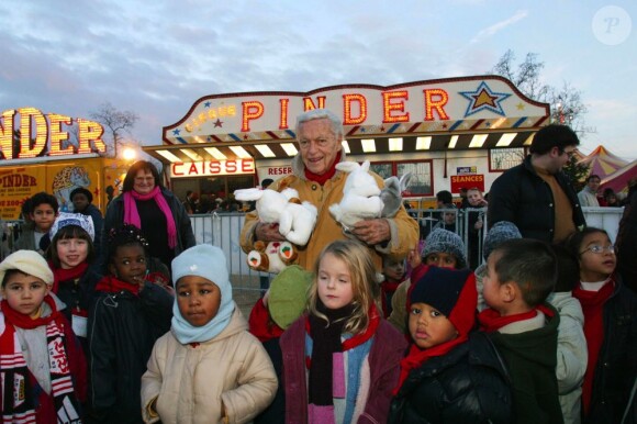 Guy Lux entouré d'enfants qu'il avait emmenés au cirque grâce à son association Pas d'enfants sans vacances, novembre 2002.