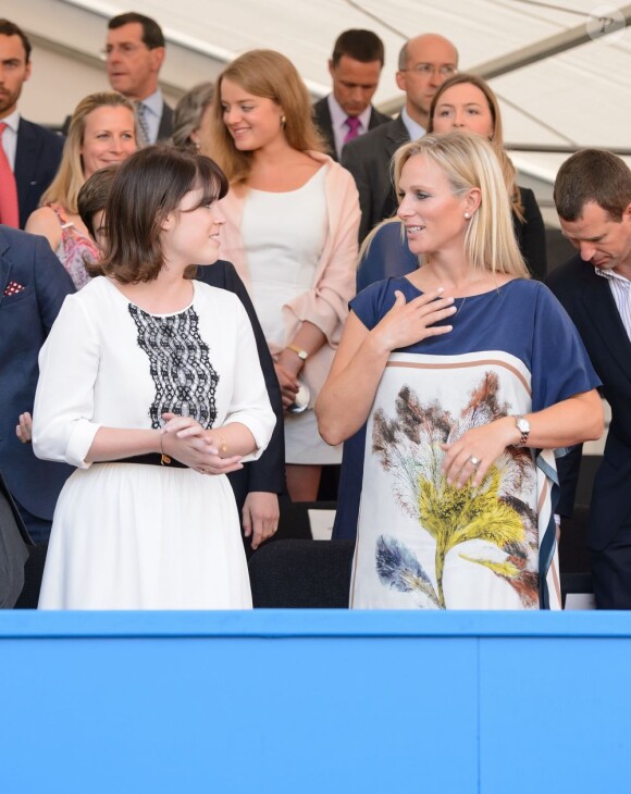 Zara Phillips, enceinte de trois mois, discute avec sa cousine la princesse Eugenie d'York dans la loge royale du premier concert du Coronation Festival, le 11 juillet 2013 dans les jardins de Buckingham Palace. Sa première apparition publique depuis l'annonce de sa grossesse.