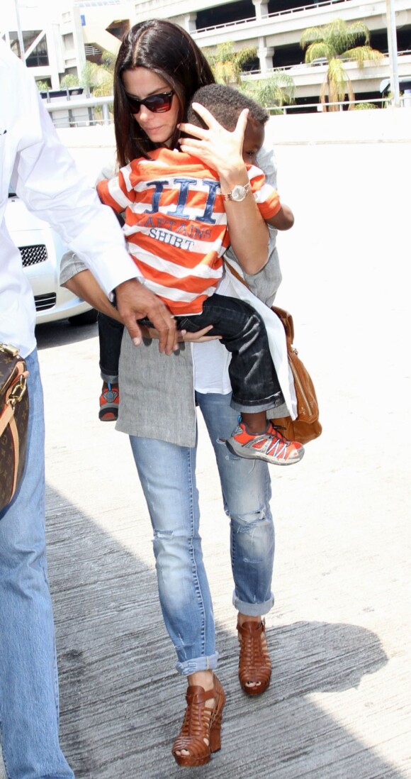 La jolie Sandra Bullock et son fils Louis prennent un vol à Los Angeles, le 12 juillet 2013.