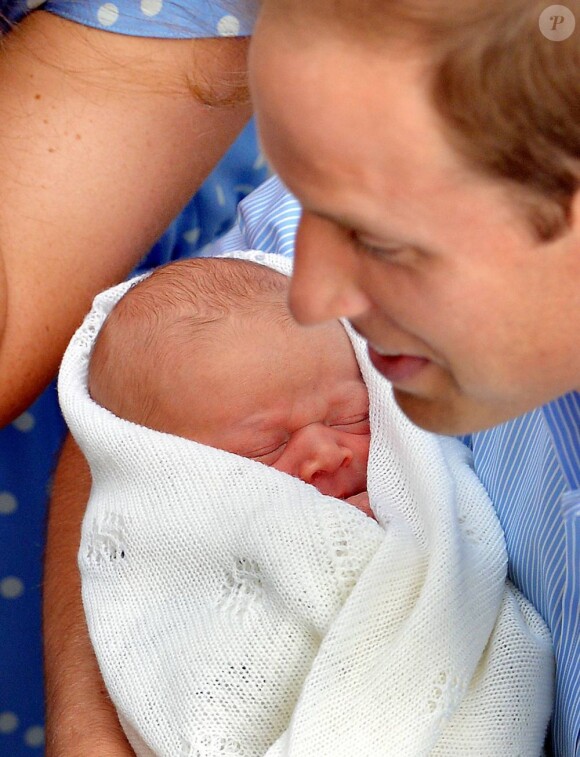 Le prince George de Cambridge prêt à rentrer chez lui avec ses parents le prince William et Kate Middleton, le 23 juillet 2013, au lendemain de sa naissance.