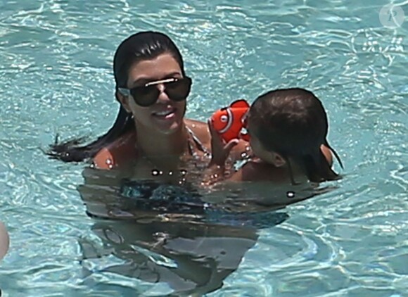 Kourtney Kardashian et Scott Disick se baignent dans une piscine avec leurs enfants Mason et Penelope a Miami, le 22 juillet 2013.  Please hide children's face prior to the publication Kourtney Kardashian spends the day with her family and friends at the pool in Miami, Florida on July 22, 2013.22/07/2013 - Miami