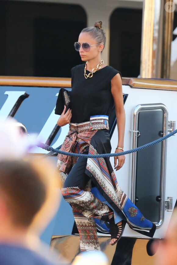 Nicole Richie, en vacances à Saint-Tropez, porte un t-shirt noir avec un pantalon et une chemise Givenchy nouée à la taille, des lunettes House of Harlow 1960 et un collier Chanel. Le 25 juillet 2013.
