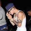 Justin Bieber se cache des photographes à la sortie du club "Milk Studios" à Hollywood, le 14 juin 2013.