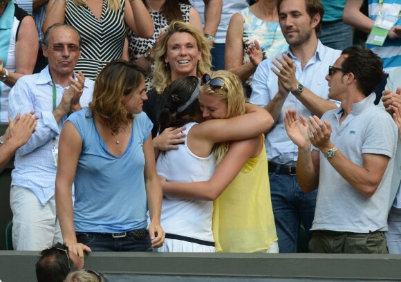 Marion Bartoli dans les bras de Kristina Mladenovic, sous les yeux d'Amélie Mauresmo, son père Walter Bartoli et Thomas Drouet, lors de son triomphe en finale de Wimbledon le 6 juillet 2013 à Londres