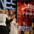 Léa Seydoux et Adèle Exarchopoulos entourant le réalisateur Abdellatif Kechiche et la Palme d'or du film La Vie d'Adèle au Festival de Cannes le 26 mai 2013