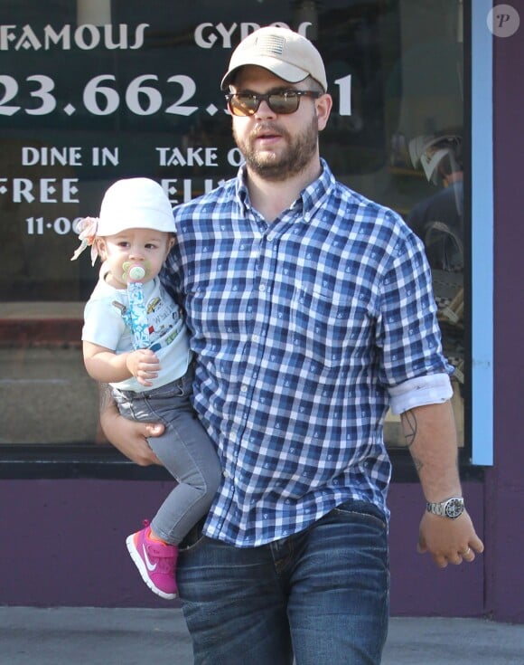 Jack Osbourne se promène, avec sa fille Pearl dans les bras, dans les rues de Los Angeles. Le 16 août 2013.