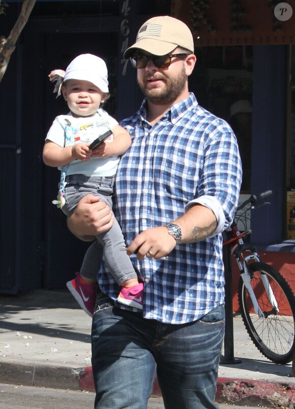 Jack Osbourne se promène, avec sa fille Pearl dans les bras, dans les rues de Los Angeles. Le 16 août 2013.