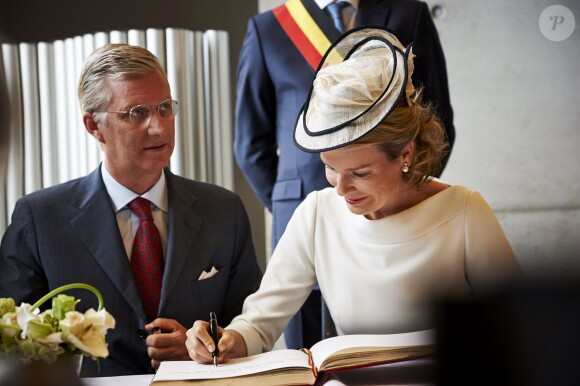 Le roi Philippe et la reine Mathilde de Belgique, signant le livre d'or, à Wavre, deuxième étape de leur tournée ''Joyeuses rentrées'', le 10 septembre 2013