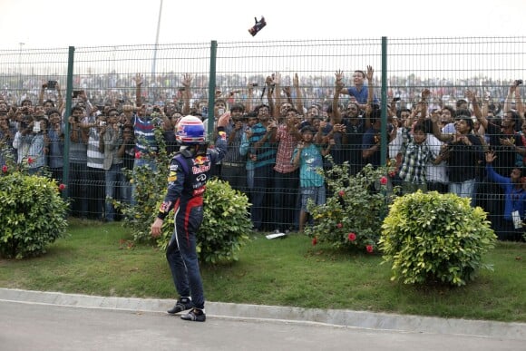 Sebastian Vettel distribue ses attributs lors de sa victoire au Grand Prix d'Inde qui lui garanti un quatrième titre de champion du monde des pilotes de suite, le 27 octobre 2013 à Greater Noida, New Delhi le 27 octobre 2013