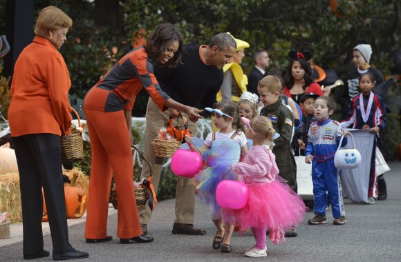 Michelle Obama, avec un dress code étudié, et Barack Obama en pleine distribution de friandises à la Maison Blanche pour Halloween le 31 octobre 2013.