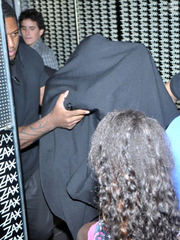 Justin Beiber sort du bordel Centauros, caché sous une couverture noire, à Rio de Janeiro, le 1er novembre 2013.