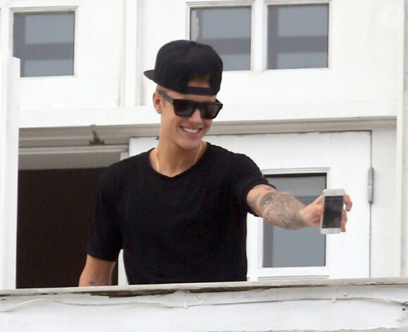 Justin Bieber salue ses fans sur le balcon de son hôtel à Rio de Janeiro, au Bresil, le 1er novembre 2013.