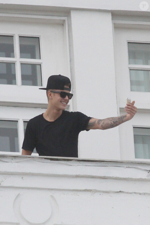 Justin Bieber salue ses fans sur le balcon de son hôtel à Rio de Janeiro, au Bresil, le 1er novembre 2013.