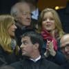 Manuel Valls, son épouse Anne Gravoin, Pierre Moscovici et sa compagne Marie-Charline Pacquot, lors du match France-Nouvelle-Zélande au Stade de France à Saint-Denis le 9 novembre 2013