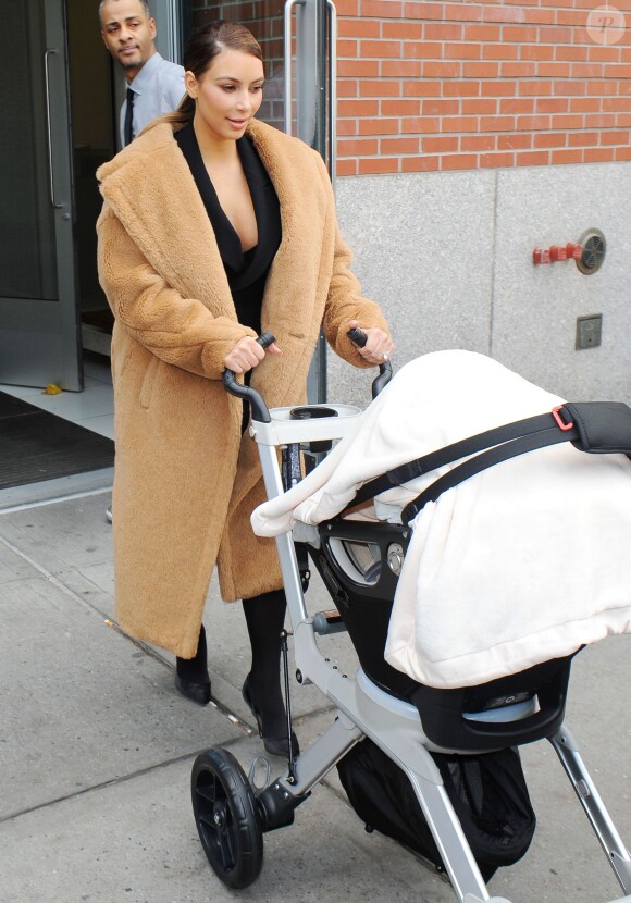 Kim Kardashian quitte l'appartement de Kanye West à SoHo avec leur fille North, habillée d'un manteau en alpaca et mohair Max Mara et de souliers Gianvito Rossi. New York, le 19 novembre 2013.