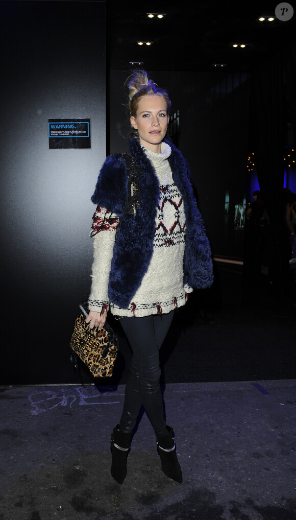 Poppy Delevingne se rend à la soirée de présentation de la nouvelle Mini à Londres, habillée d'une veste en fourrure bleue, d'un pull et d'un pantalon Isabel Marant pour H&M, et de bottines en suède Saint Laurent. Le 18 novembre 2013.