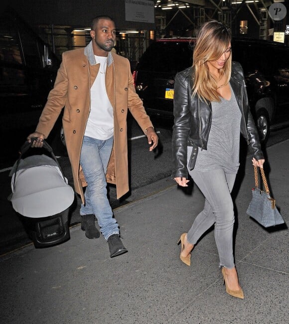 Kanye West, papa stylé en manteau Maison Martin Margiela pour H&M, de sortie à New York avec sa fiancée Kim Kardashian et leur fille North. Le 22 novembre 2013.