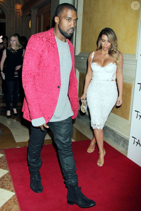 Kanye West fête le 33e anniversaire de sa fiancée Kim Kardashian, habillée d'une veste rouge Comme des Garçons Homme Plus (collection automne-hiver 2013), un top gris, un pantalon et des chaussures noires. Las Vegas, le 25 octobre 2013.