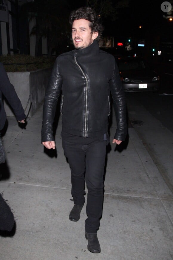 Orlando Bloom, aperçu en pleine rue à Los Angeles, porte une veste à zip asymétrique Rick Owens (collection automne-hiver 2012), un pantalon et des bottines noires. Le 21 janvier 2013.