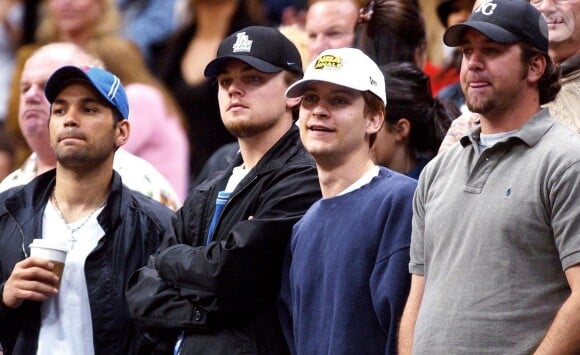 Leonardo DiCaprio et son demi-frère Adam Farrar, ici à gauche de Tobey Maguire, devant un match de basket à Los Angeles, en mars 2003.