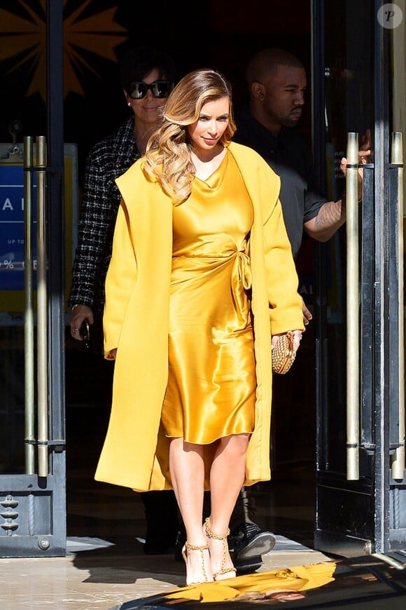 Kim Kardashian, lumineuse dans son manteau Max Mara, quitte le centre commercial Barneys New York avec son fiancé Kanye West et sa mère Kris Jenner. Beverly Hills, le 11 décembre 2013.