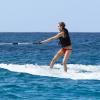 Cara Delevingne s'essaie au ski nautique sur une planche de surf lors de ses vacances à la Barbade, le 27 décembre 2013.