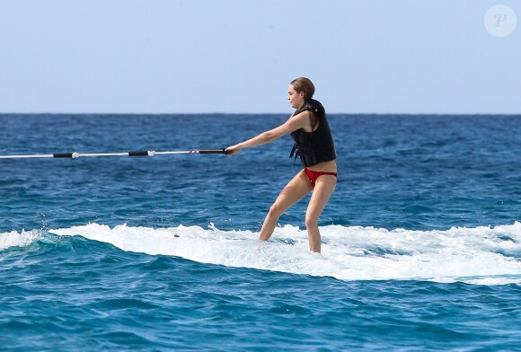 Cara Delevingne s'essaie au ski nautique sur une planche de surf lors de ses vacances à la Barbade, le 27 décembre 2013.