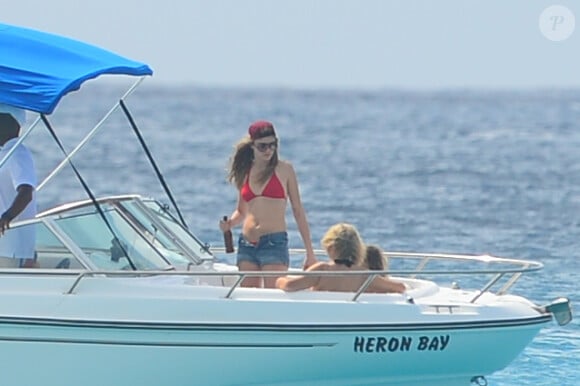 Cara Delevingne s'essaie au ski nautique sur une planche de surf lors de ses vacances à la Barbade, le 27 décembre 2013.
