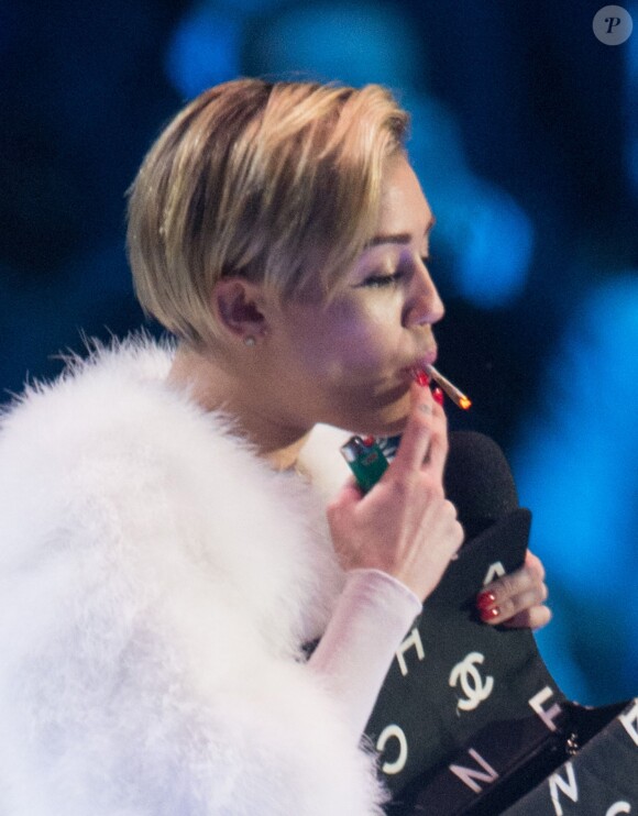 Miley Cyrus fume un joint sur la scène du Ziggo Dome à Amsterdam, le 10 novembre 2013.