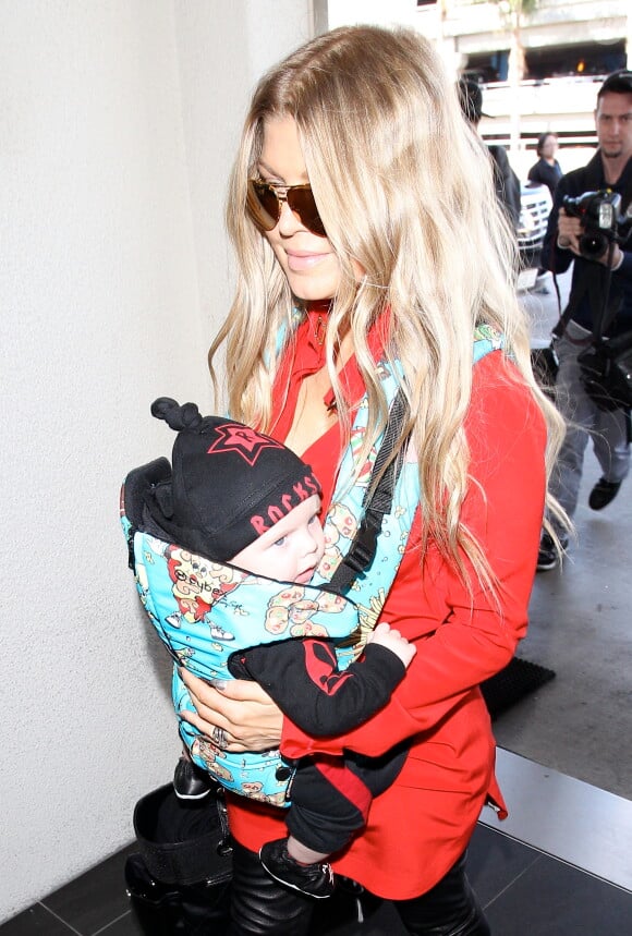 Fergie prend un vol à l'aéroport de Los Angeles avec son fils Axl, le 10 février 2014.